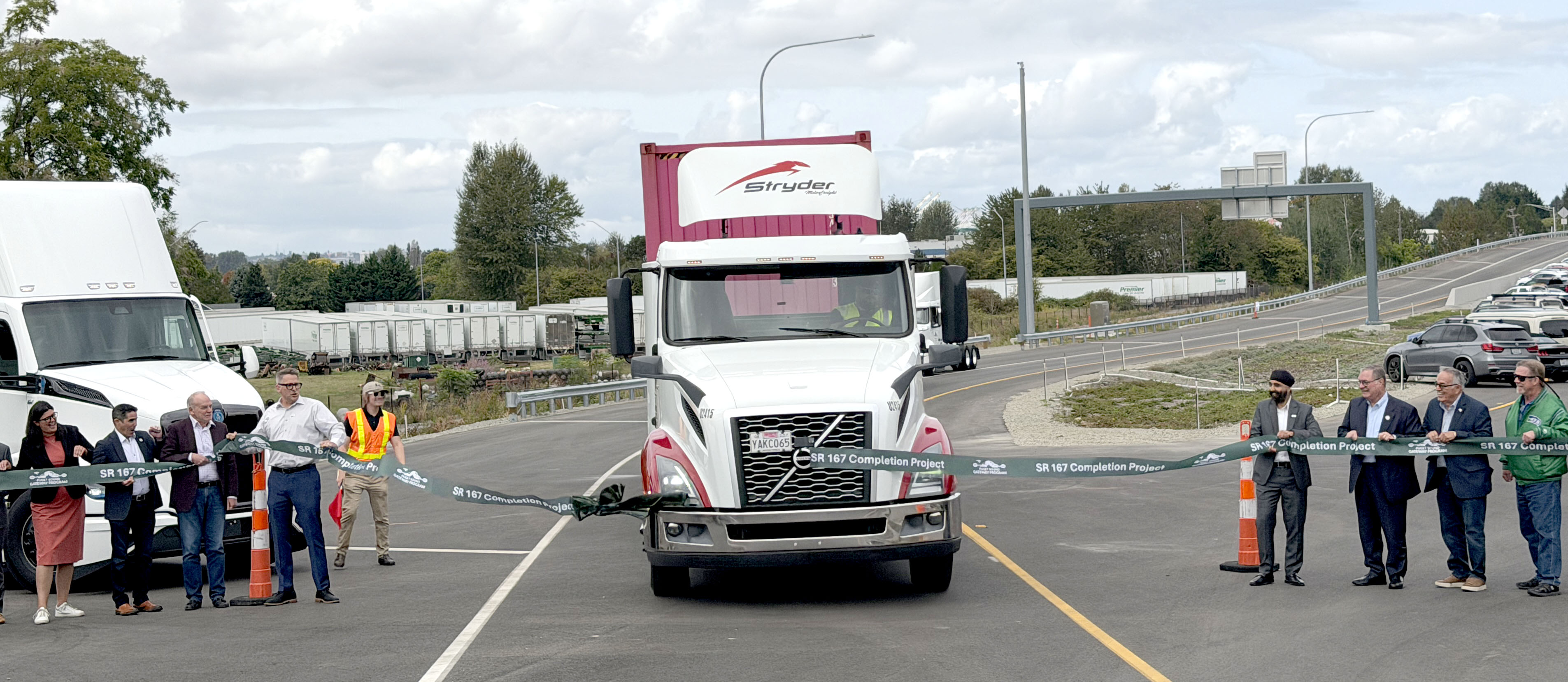 A drayage truck drives through a ribbon during a ceremonial opening of the new section of State Route 167 in north Pierce County on Friday, September 11, 2026.